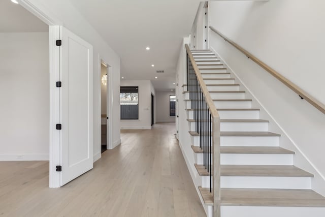 staircase with recessed lighting, visible vents, baseboards, and wood finished floors