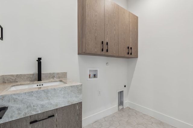 washroom featuring electric dryer hookup, washer hookup, a sink, cabinet space, and baseboards