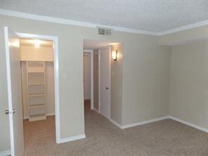 unfurnished room featuring carpet flooring, baseboards, visible vents, and ornamental molding