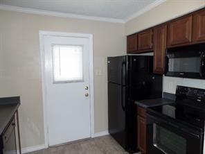 kitchen with baseboards, dark countertops, black appliances, and ornamental molding