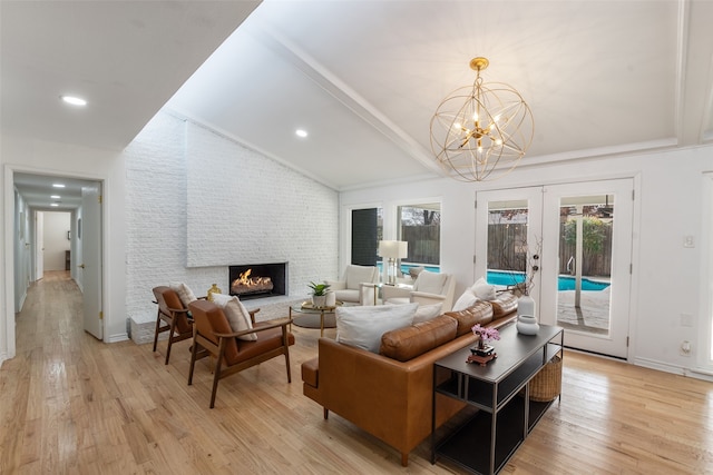 living room with light wood-style flooring, recessed lighting, french doors, a fireplace, and lofted ceiling