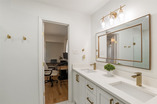 full bathroom featuring double vanity, wood finished floors, and a sink