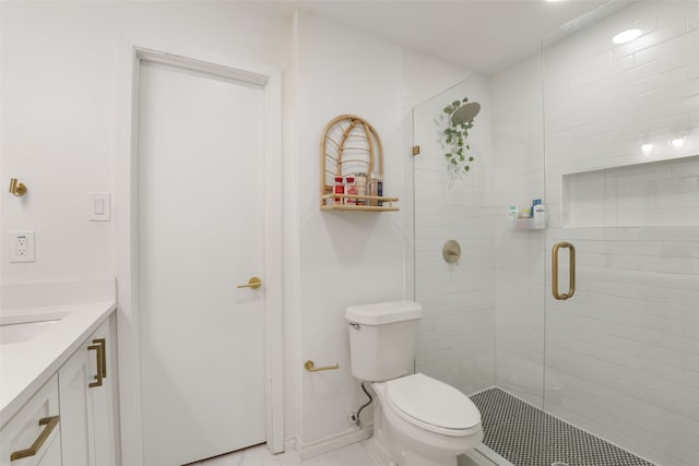 bathroom featuring a shower stall, toilet, vanity, and baseboards