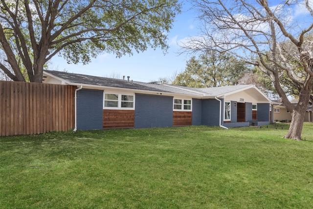 view of front of property featuring brick siding, a front yard, and fence