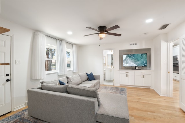 living area featuring light wood finished floors, visible vents, and recessed lighting