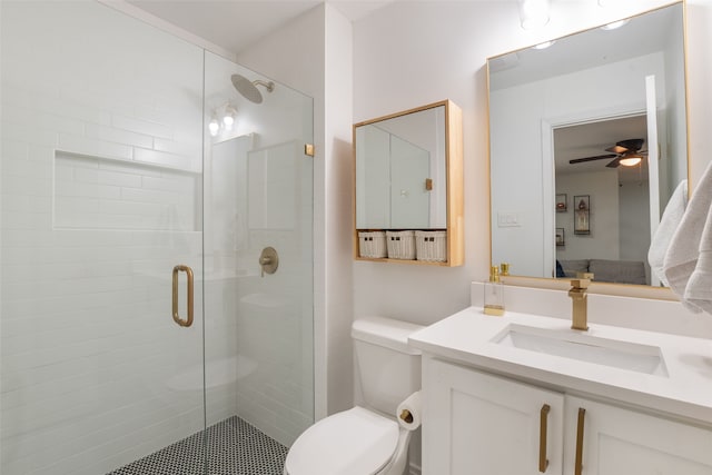 bathroom featuring a shower stall, toilet, vanity, and a ceiling fan