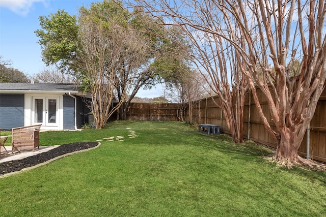 view of yard featuring french doors and a fenced backyard