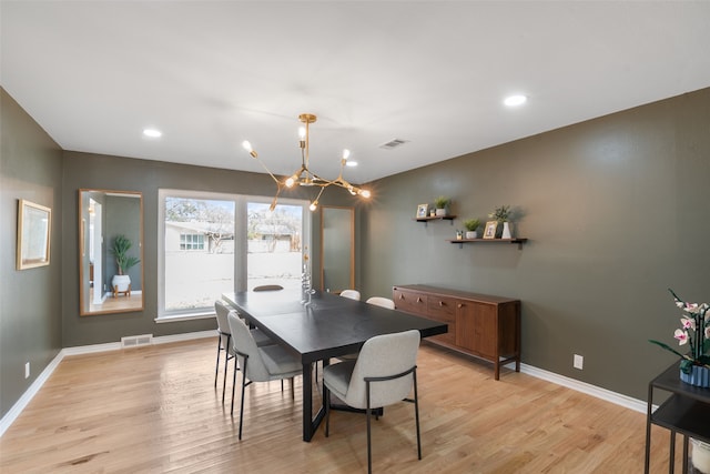 dining space featuring light wood finished floors, visible vents, and baseboards