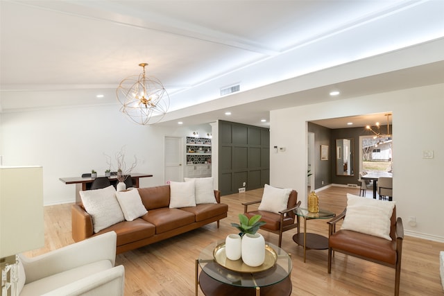 living area featuring baseboards, visible vents, light wood finished floors, and a chandelier