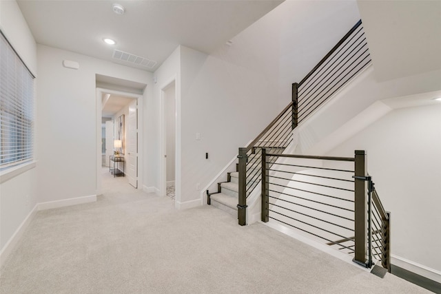 stairway with recessed lighting, visible vents, baseboards, and carpet floors