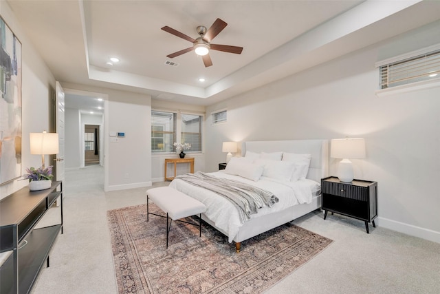 bedroom featuring visible vents, baseboards, light carpet, recessed lighting, and a raised ceiling