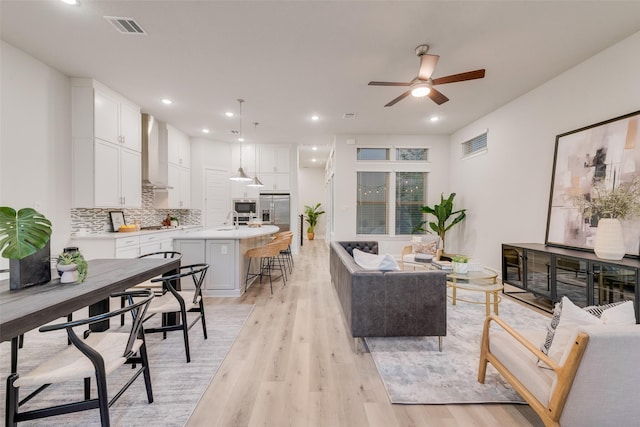 living room with recessed lighting, visible vents, and light wood-style floors