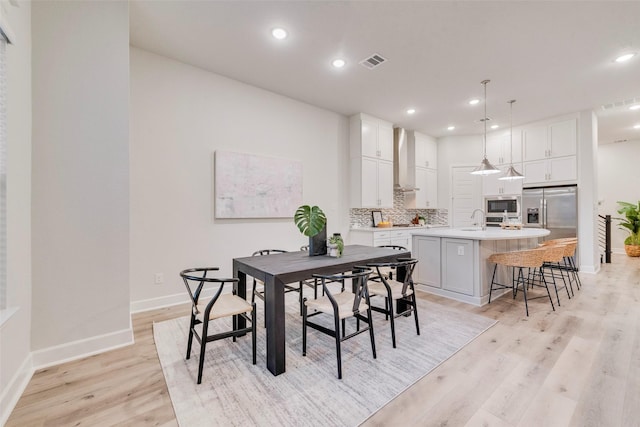 dining space featuring light wood-type flooring, visible vents, baseboards, and recessed lighting