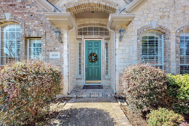 view of exterior entry with brick siding and stone siding