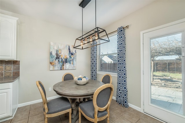 dining space featuring light tile patterned floors and baseboards