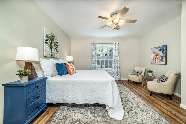 bedroom with ceiling fan, baseboards, and wood finished floors