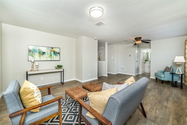 living area featuring visible vents, baseboards, wood finished floors, and a ceiling fan