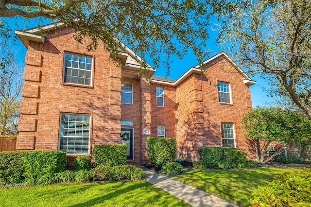 view of front of home with brick siding and a front yard