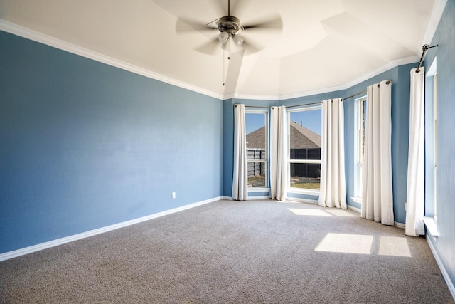 carpeted spare room with lofted ceiling, a ceiling fan, baseboards, and ornamental molding