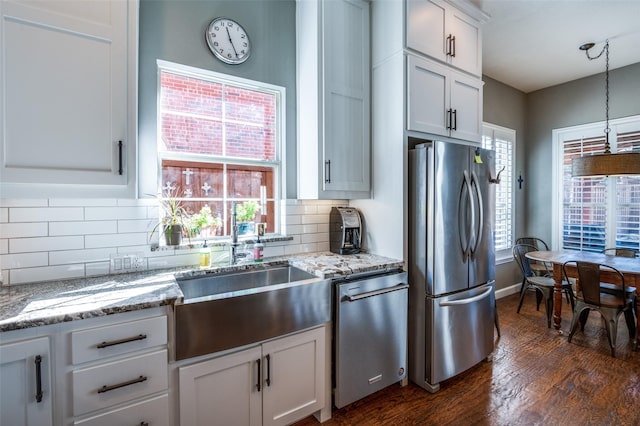 kitchen featuring backsplash, dark wood-style flooring, appliances with stainless steel finishes, white cabinets, and a sink