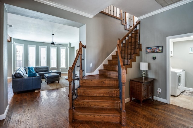 stairs featuring ornamental molding, washer / clothes dryer, wood finished floors, baseboards, and ceiling fan