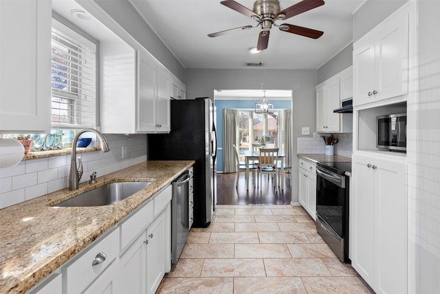 kitchen with a sink, stainless steel appliances, and white cabinetry