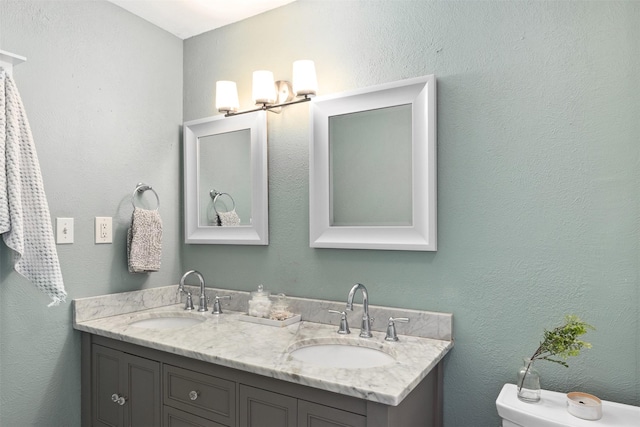 bathroom with a sink, double vanity, and a textured wall