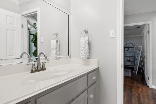 bathroom featuring wood finished floors, vanity, and crown molding