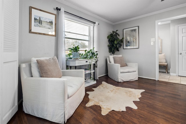 sitting room featuring wood finished floors, baseboards, and ornamental molding