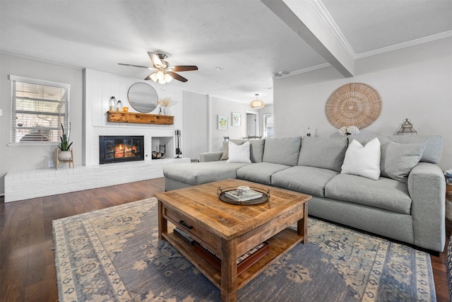 living room featuring a wealth of natural light, ornamental molding, a brick fireplace, and wood finished floors