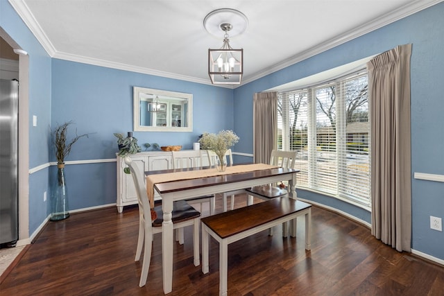 dining area featuring baseboards, a notable chandelier, wood finished floors, and ornamental molding