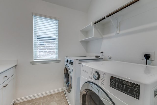 laundry room featuring light tile patterned flooring, washing machine and dryer, cabinet space, and baseboards