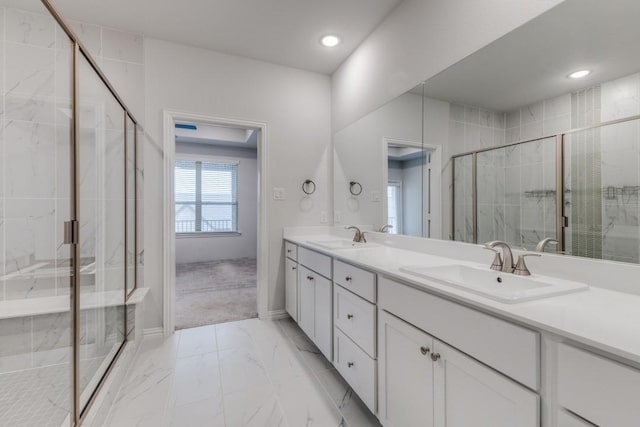 bathroom featuring double vanity, a stall shower, marble finish floor, and a sink