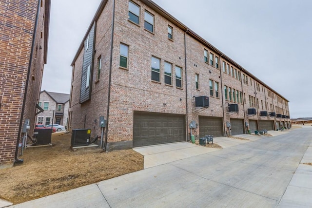 view of building exterior featuring central air condition unit and a garage