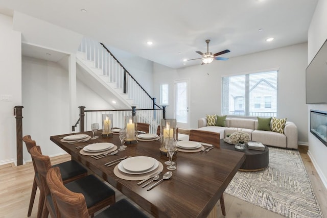 dining area with stairs, recessed lighting, light wood-type flooring, and a wealth of natural light