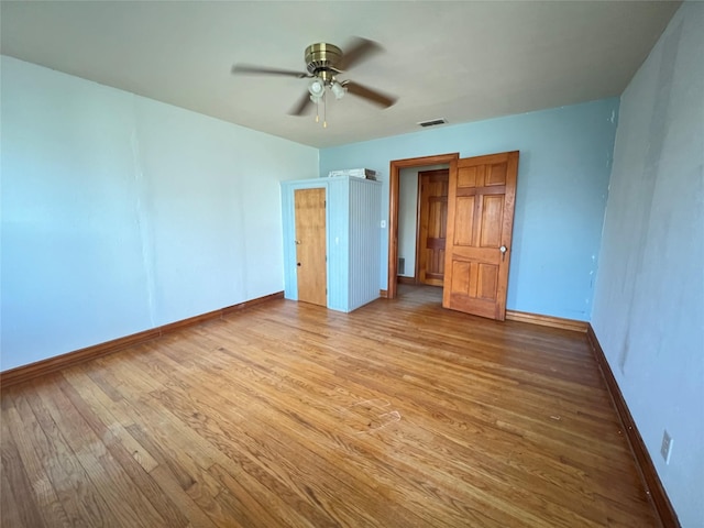 unfurnished bedroom featuring visible vents, a ceiling fan, baseboards, and wood finished floors