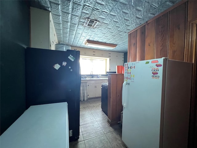 kitchen with visible vents, an ornate ceiling, freestanding refrigerator, and a sink