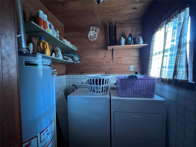 washroom with gas water heater, wooden walls, separate washer and dryer, wood ceiling, and laundry area