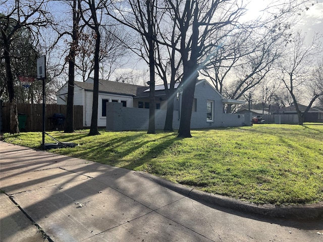 view of front facade featuring brick siding, a front lawn, and fence