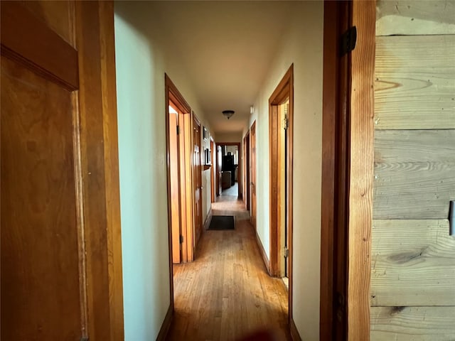 corridor with hardwood / wood-style flooring