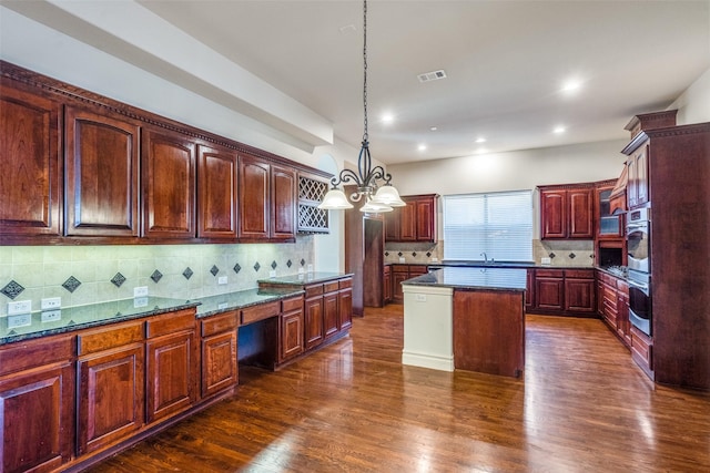 kitchen featuring decorative backsplash, a kitchen island, dark wood-style floors, and hanging light fixtures