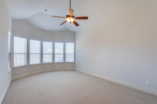 unfurnished room with a ceiling fan, lofted ceiling, light colored carpet, and baseboards