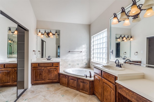 full bath featuring a garden tub, two vanities, tile patterned floors, and a sink