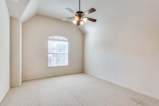 empty room featuring light carpet, baseboards, lofted ceiling, and a ceiling fan