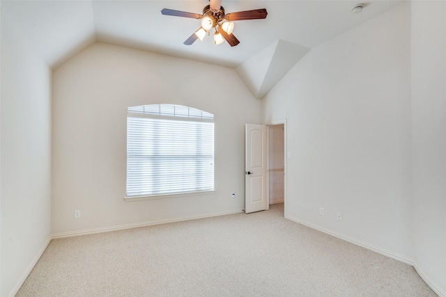 carpeted empty room with baseboards, lofted ceiling, and a ceiling fan