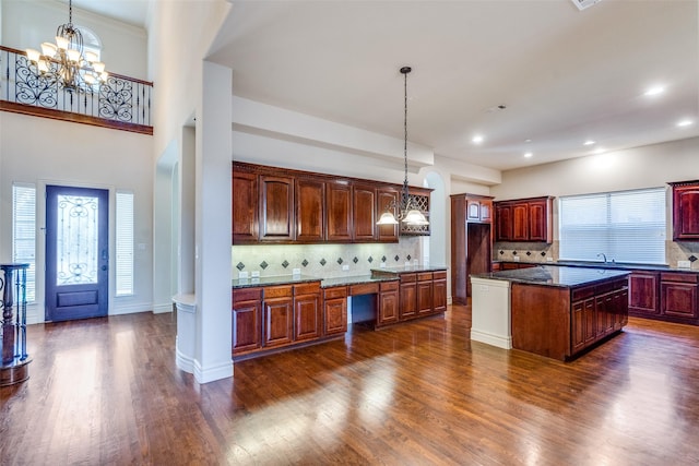 kitchen with decorative backsplash, dark wood-type flooring, and an inviting chandelier