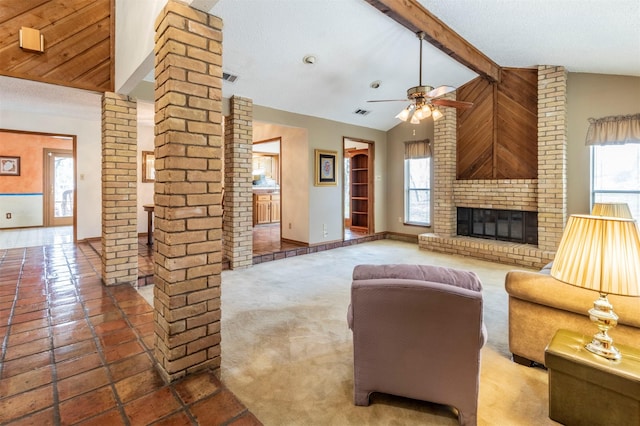 living area featuring a wealth of natural light, ceiling fan, vaulted ceiling with beams, and ornate columns