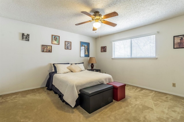 bedroom featuring carpet flooring, a textured ceiling, baseboards, and a ceiling fan