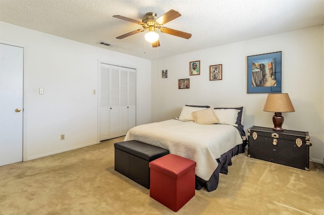 bedroom featuring visible vents, ceiling fan, a closet, a textured ceiling, and carpet flooring