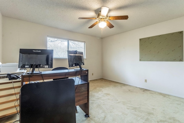 office area with baseboards, carpet, ceiling fan, and a textured ceiling